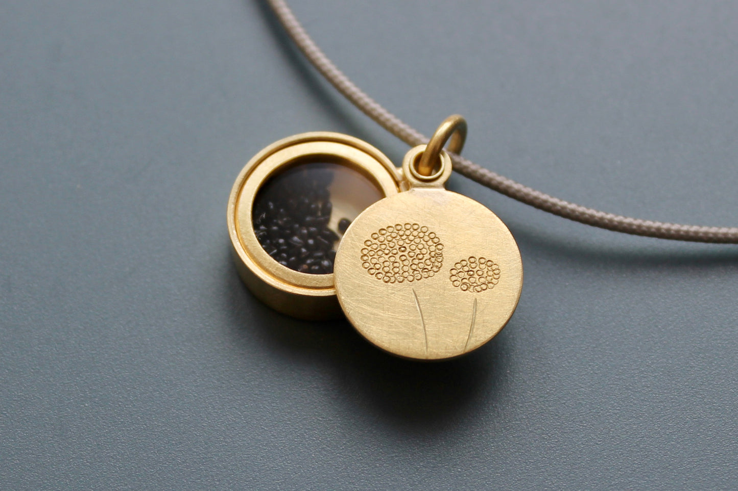 golden dandelion locket filled with forget me not seeds
