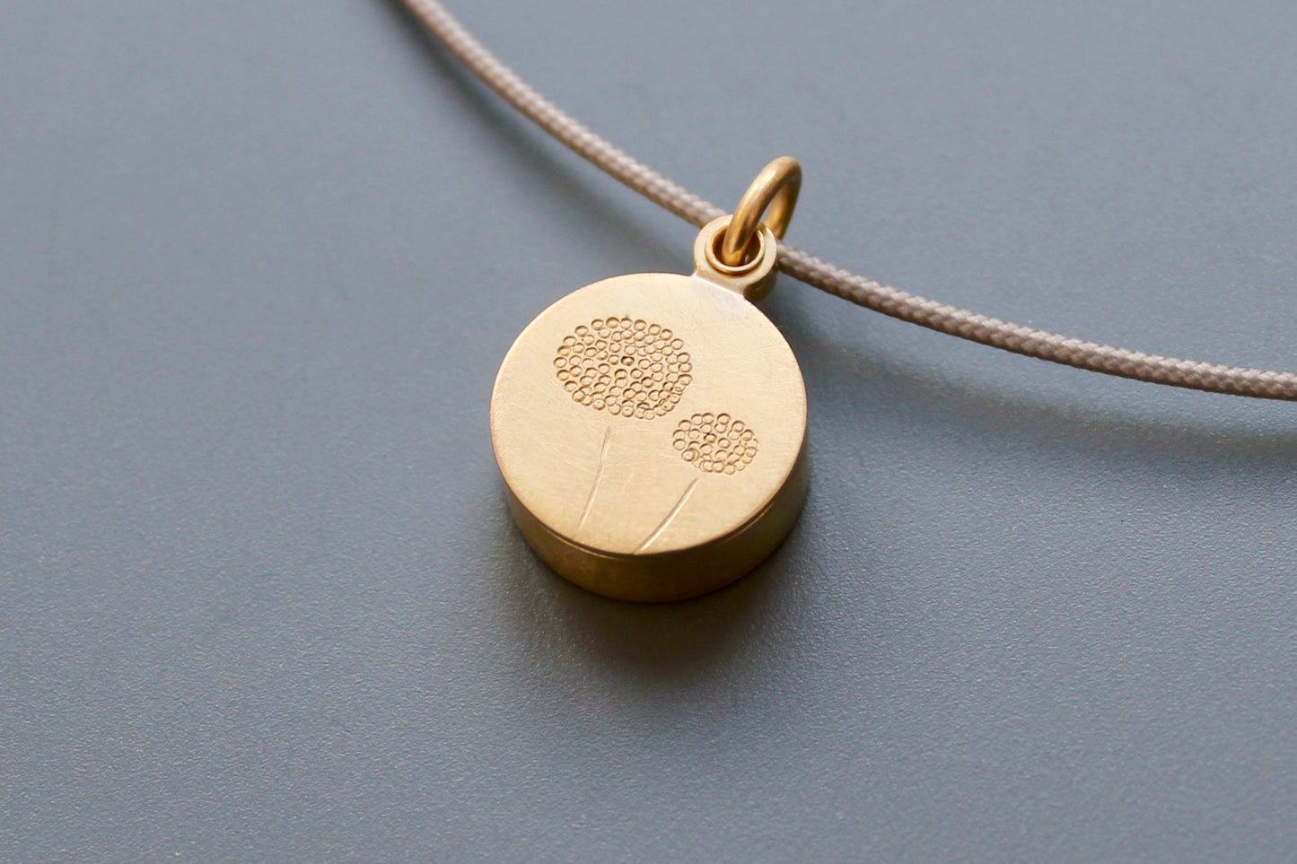 golden dandelion locket filled with forget me not seeds