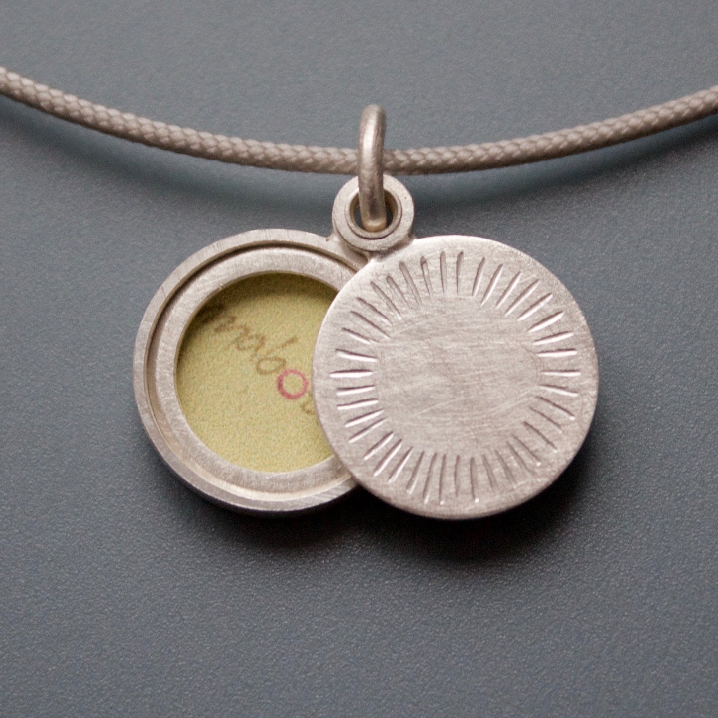 small round locket with aureole design in sterling silver