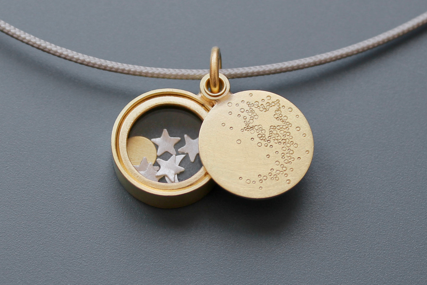 golden floating locket with shooting star