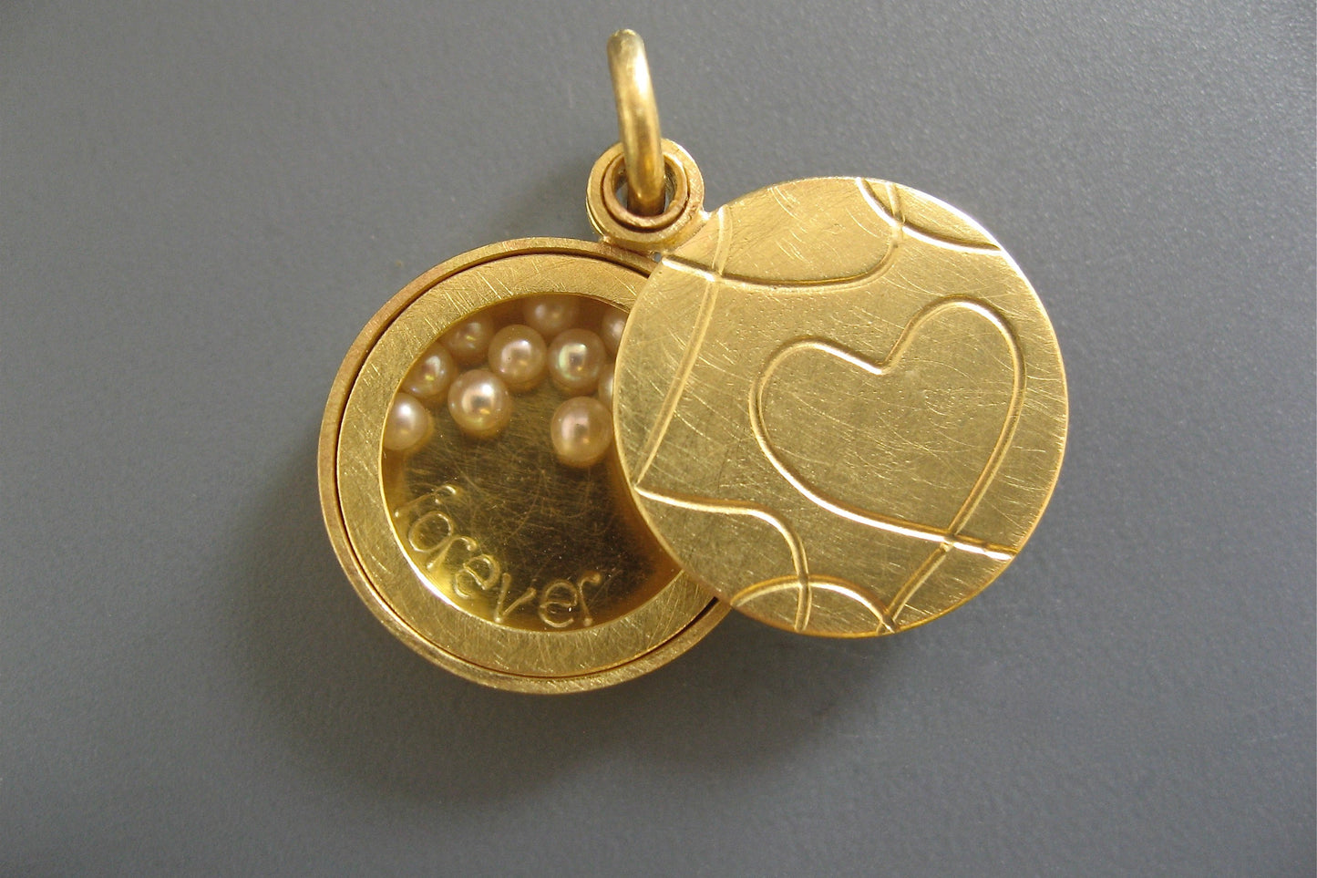 goldenes Glasmedaillon mit Perlen gefüllt mit elegantem Herzdesign