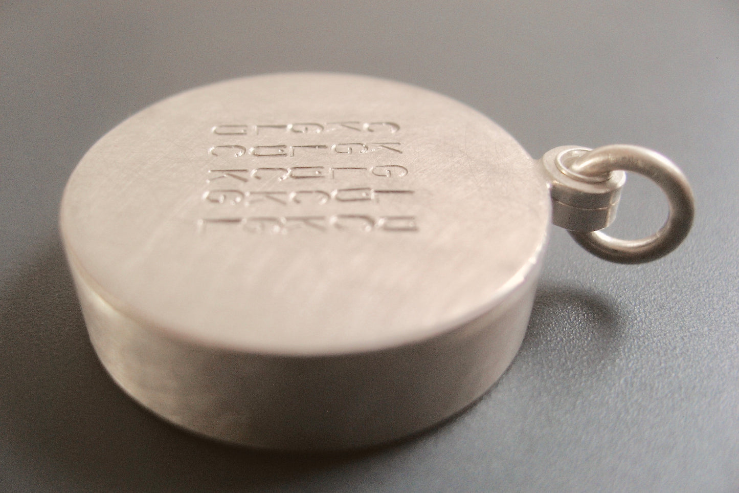 custom glass locket with floating name plates in sterling silver with typographic design