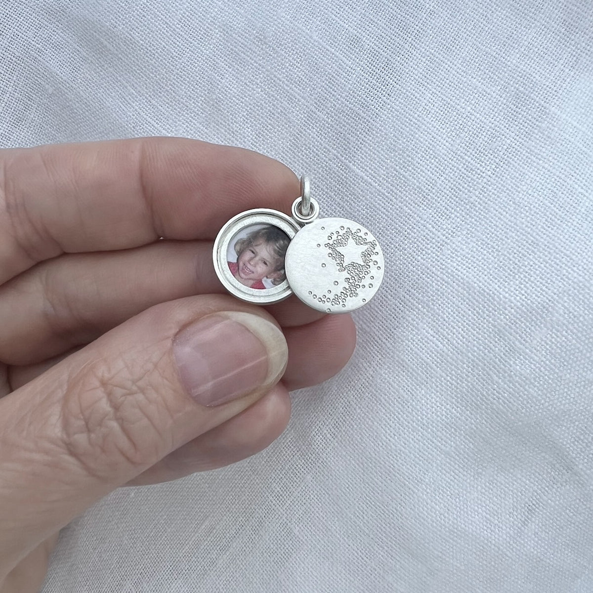 tiny sterling silver photo locket with a shooting star