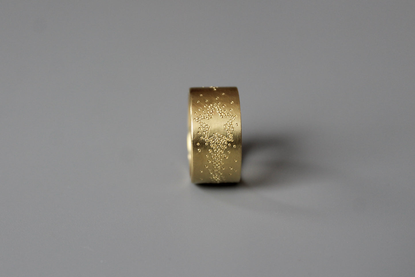 wide golden band ring with shooting star design