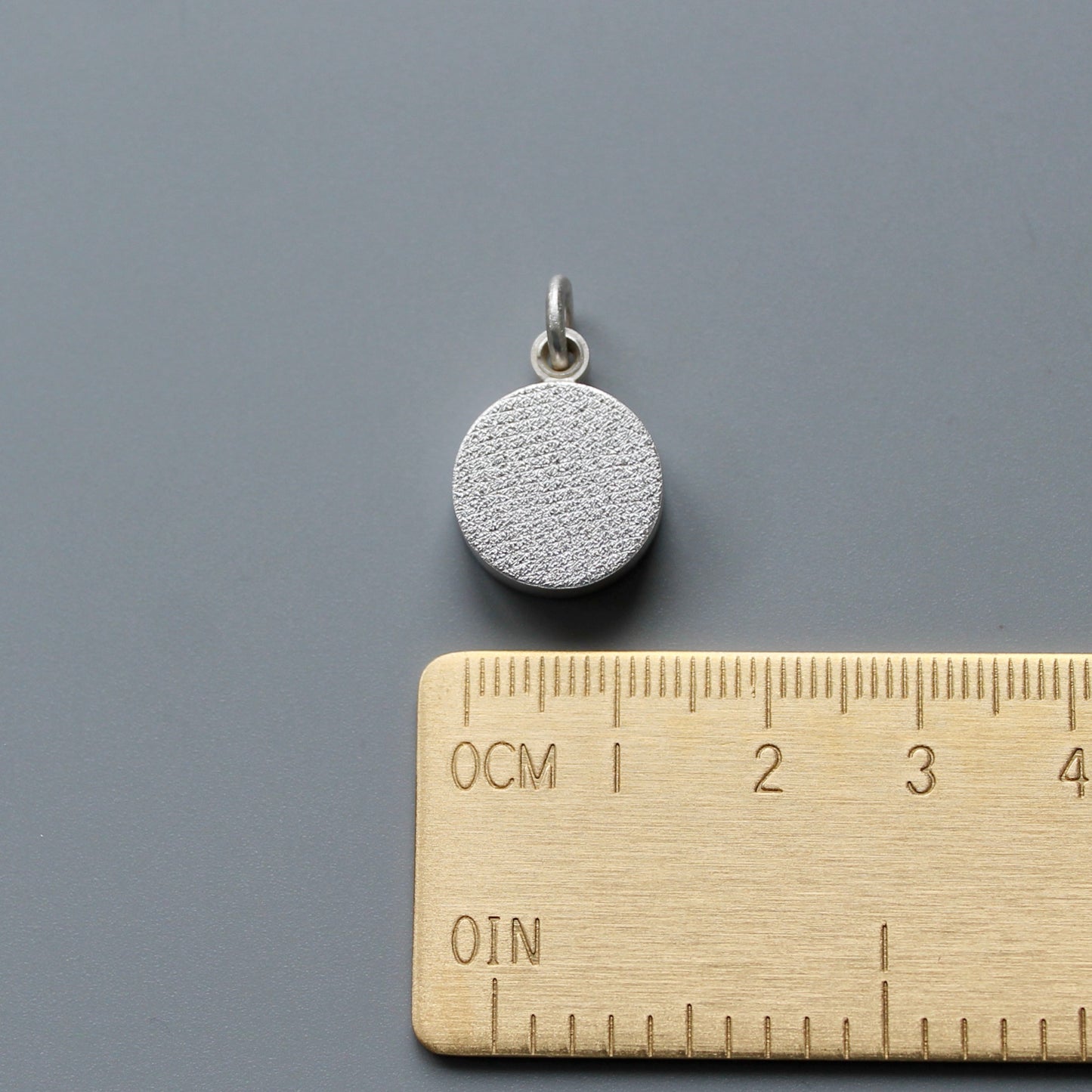 minimalist modern locket for two small photos made from textured sterling silver