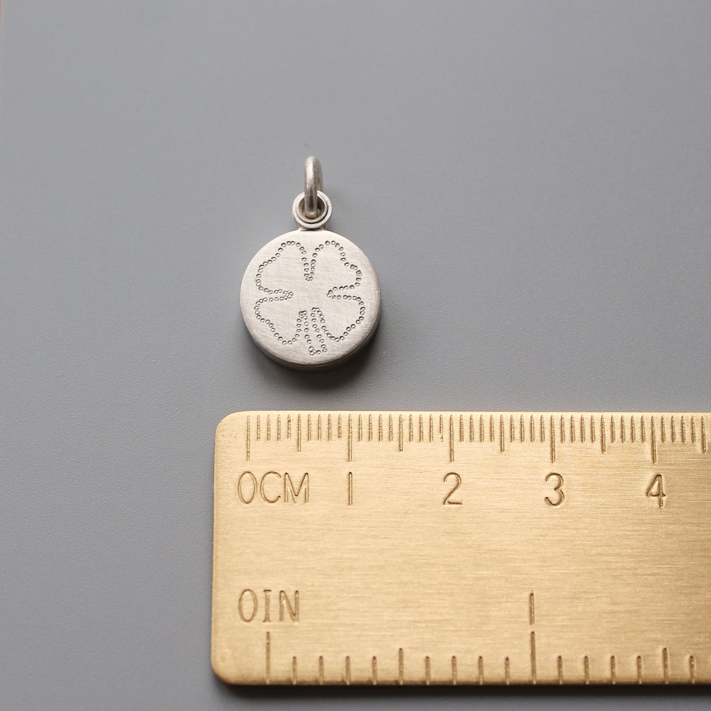 kleines silbernes Medaillon für ein Foto mit Kleeblatt als Glücksbringer 