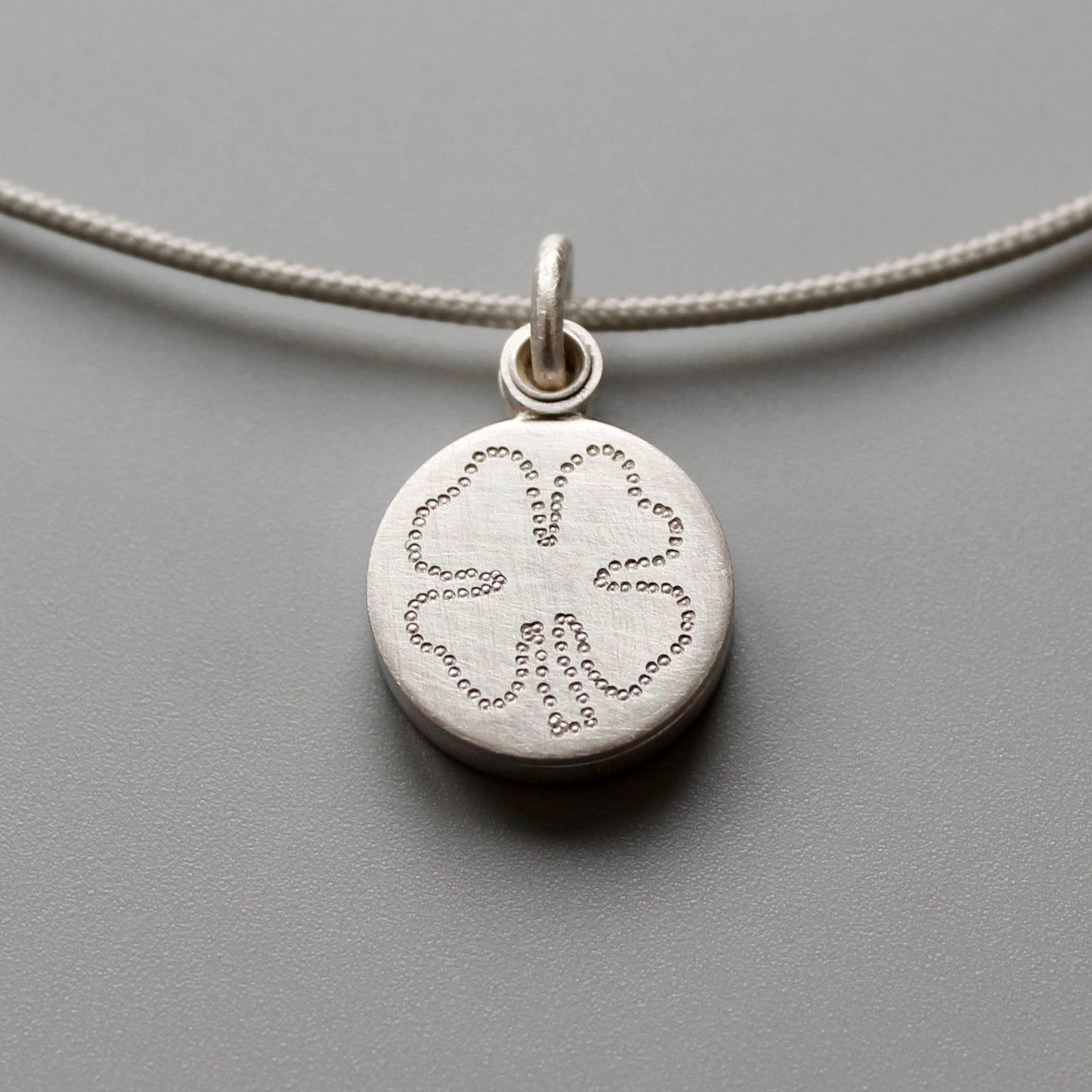 kleines silbernes Medaillon für ein Foto mit Kleeblatt als Glücksbringer 