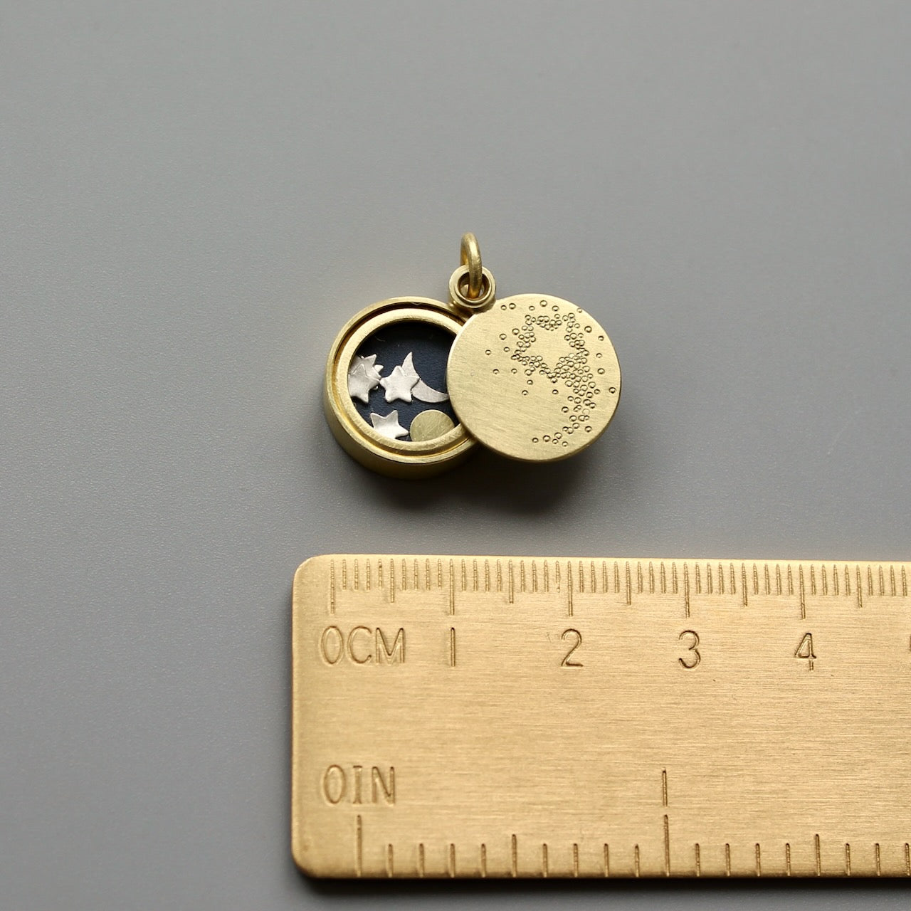 golden floating locket with shooting star