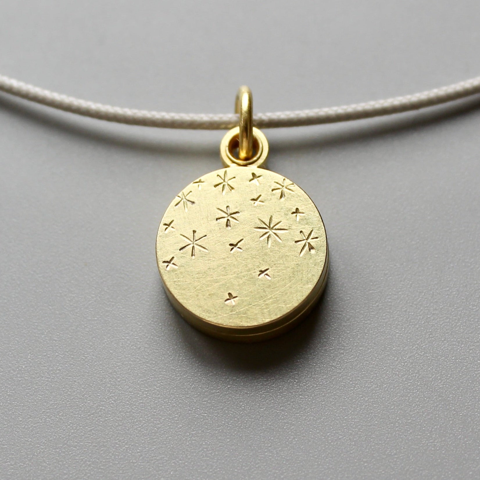Small round locket for two photos with stars engraved on the lid in 18ct gold