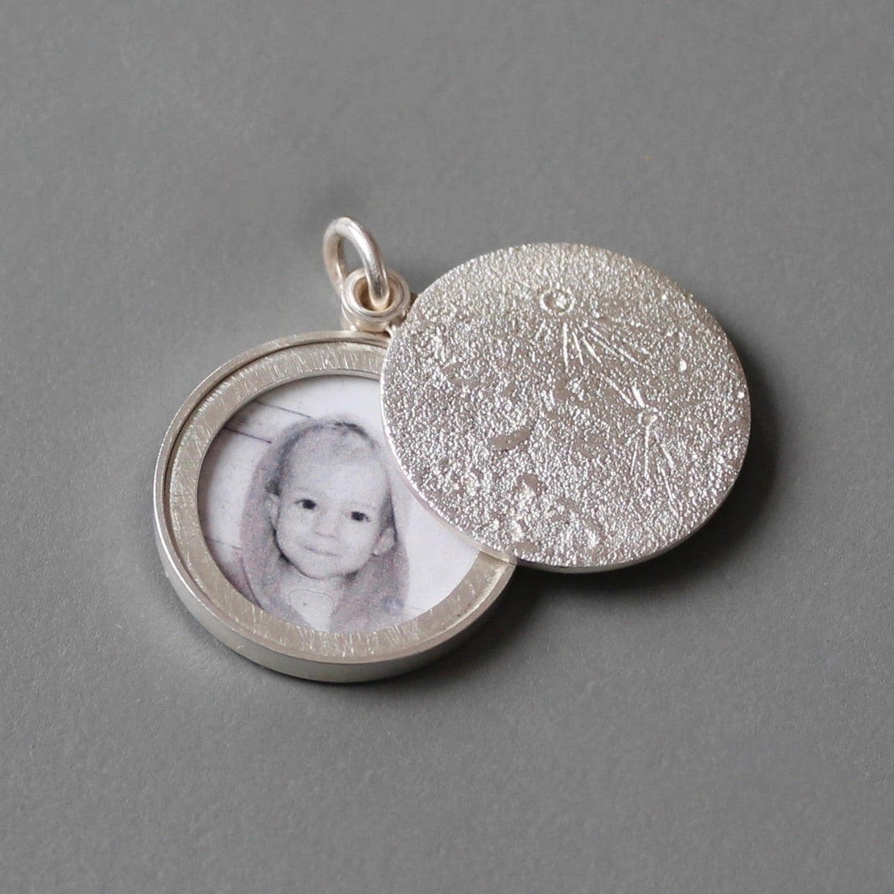 round silver photo locket with  moon surface texture