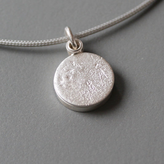 small round locket with moon surface texture made from sterling silver