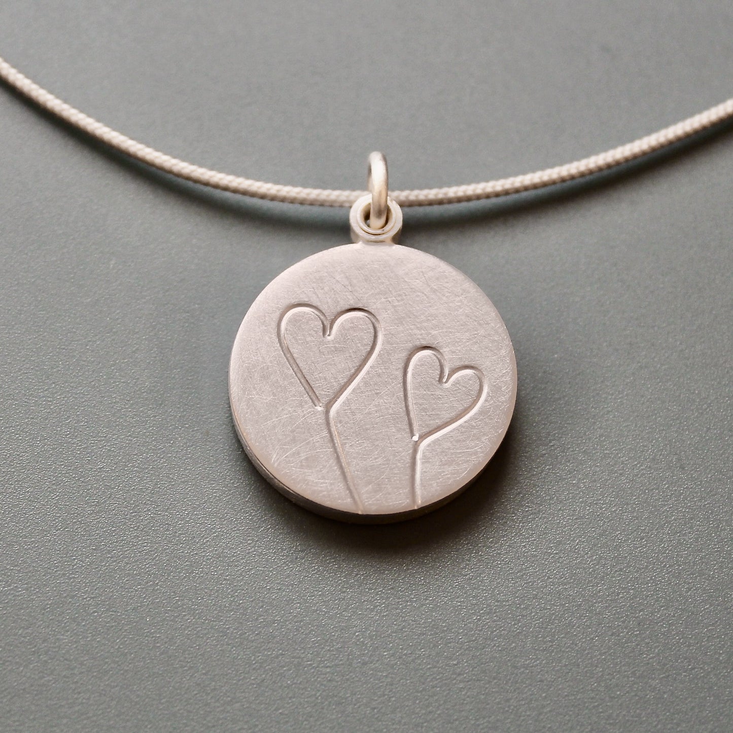 romantic silver photo locket with symbolic two hearts design
