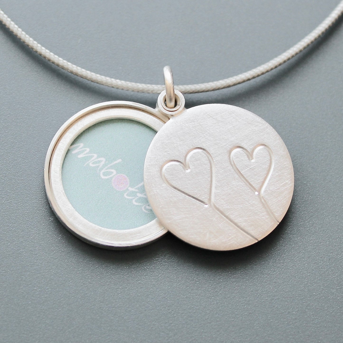 romantic silver photo locket with symbolic two hearts design