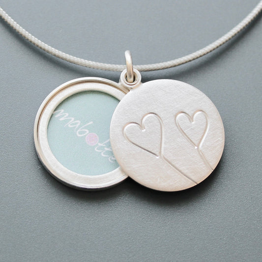 romantic silver photo locket with symbolic two hearts design