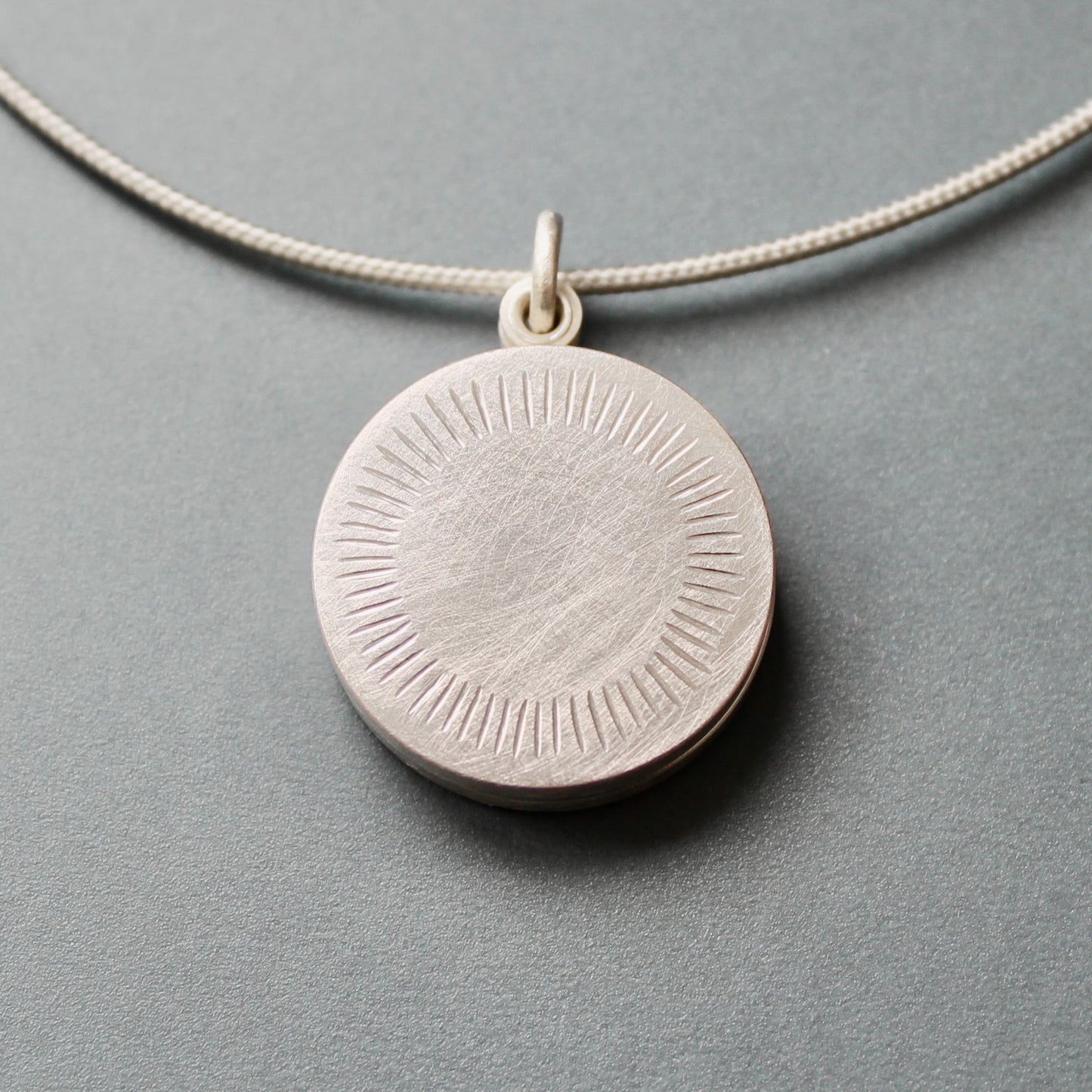 Minimalist silver locket for two pictures with aureole