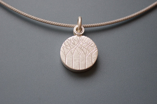 kleines Medaillon aus Silber für ein Foto mit Wald