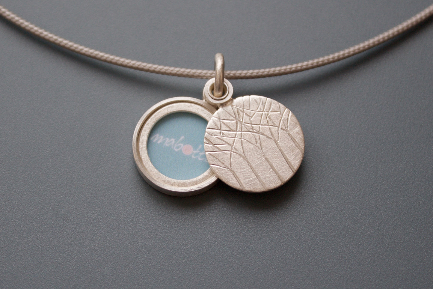 kleines Medaillon aus Silber für ein Foto mit Wald