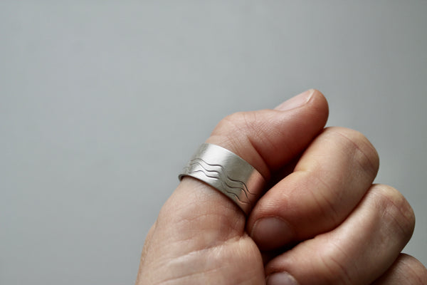 wide silver band ring with waves design