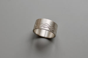 wide silver band ring with waves design