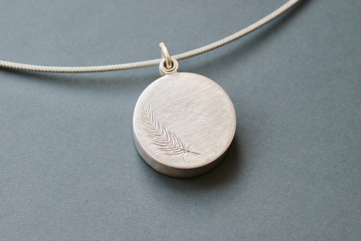secret message locket filled with silver letter plates, a tiny feather and a golden heart