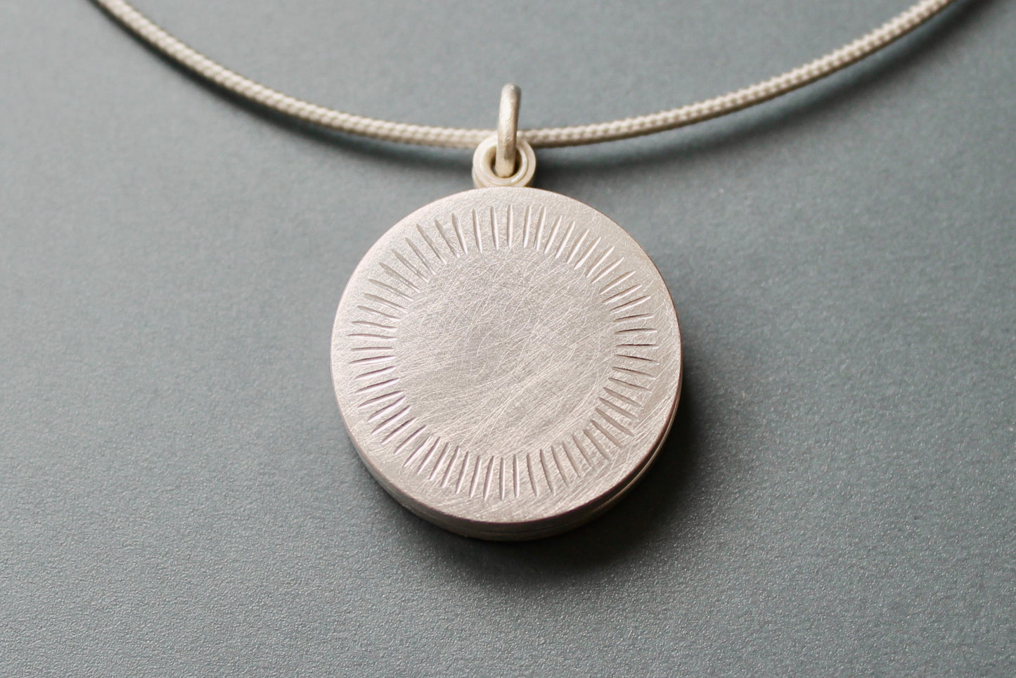 Minimalist silver locket for two pictures with aureole