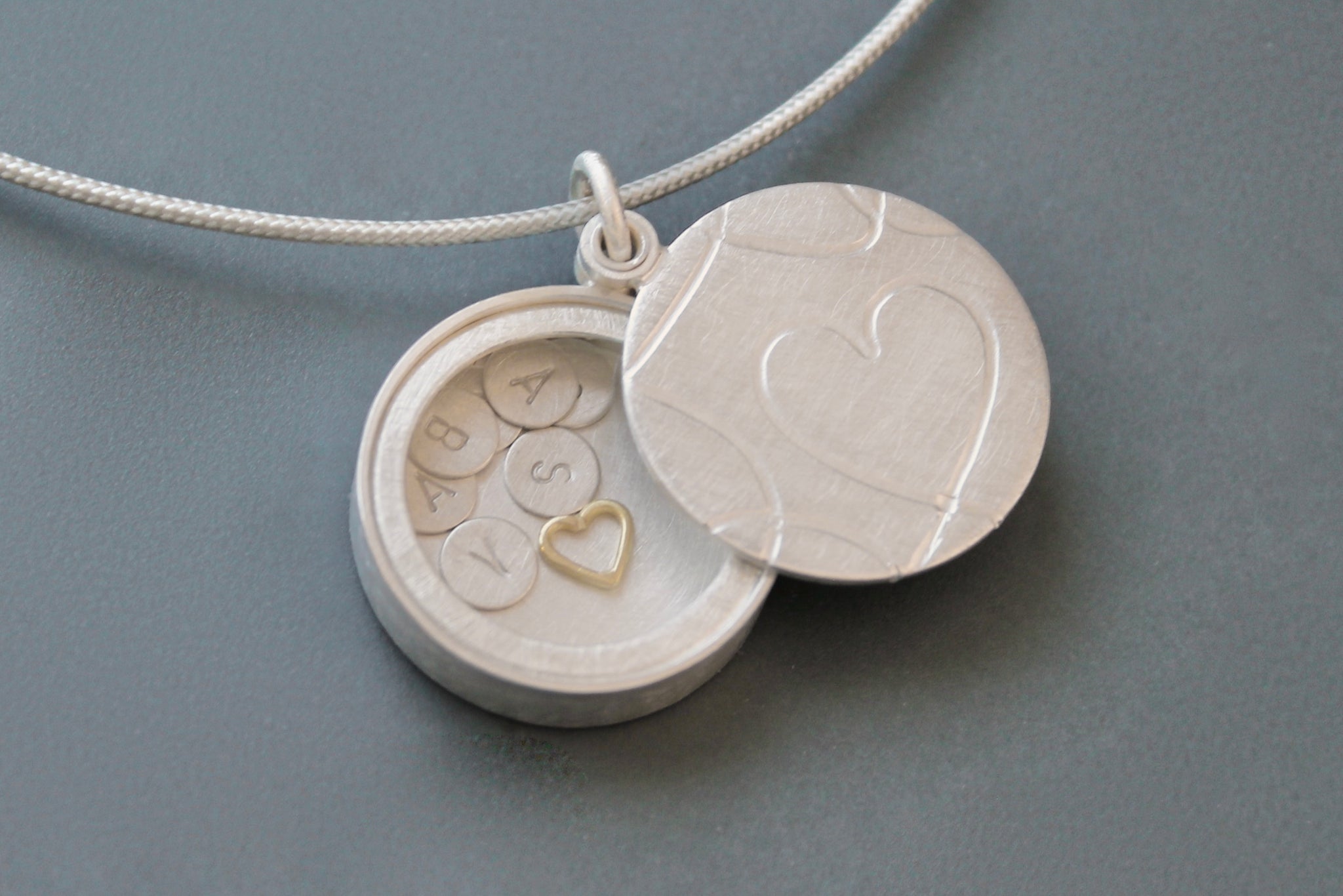 secret silver heart locket filled with letter plates and a golden heart