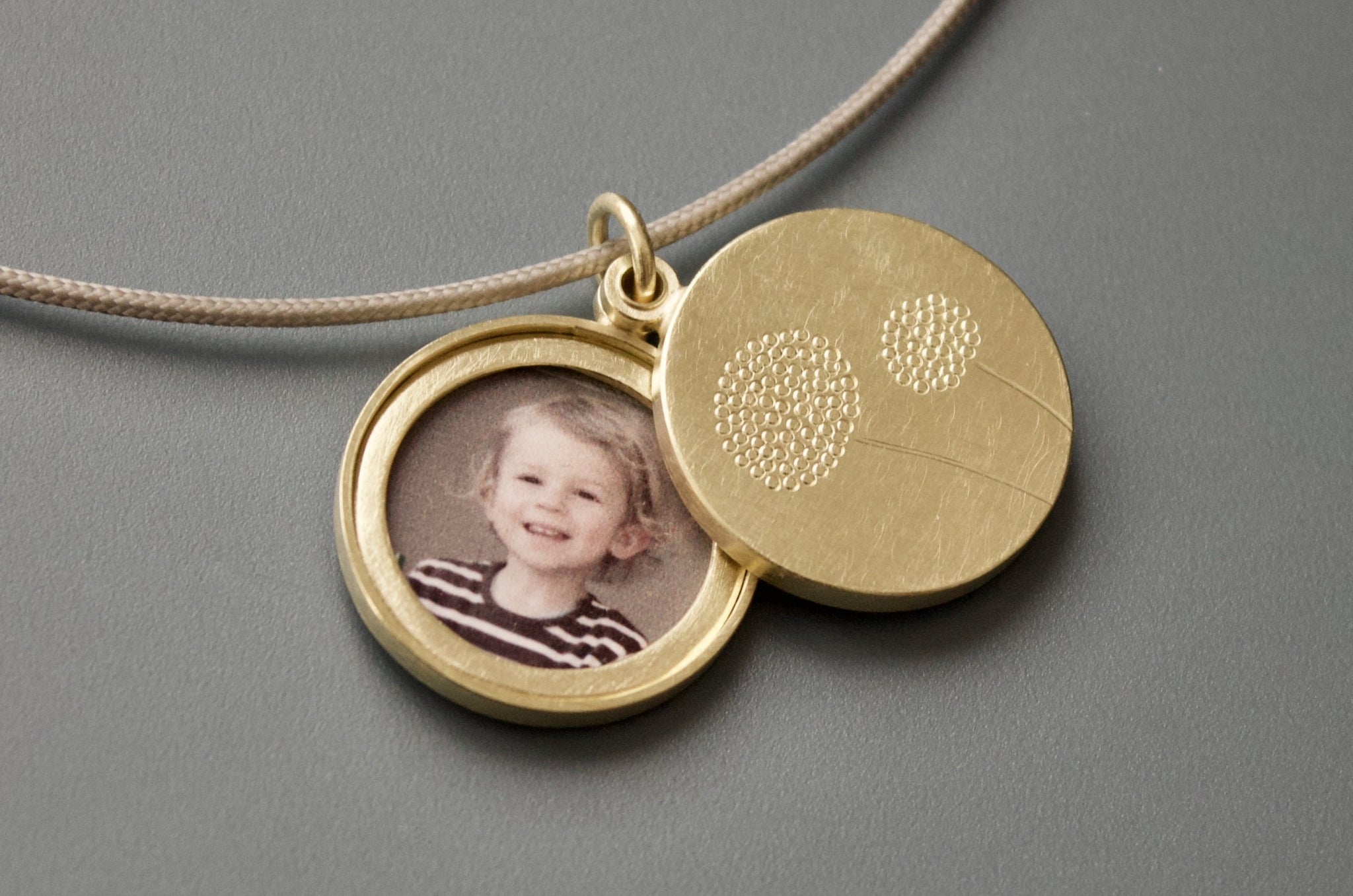 modernes Goldmedaillon für zwei Fotos mit Pusteblumen