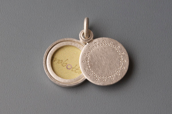 small silver locket with delicate lace patter