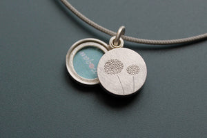 small silver double locket with delicate dandelions