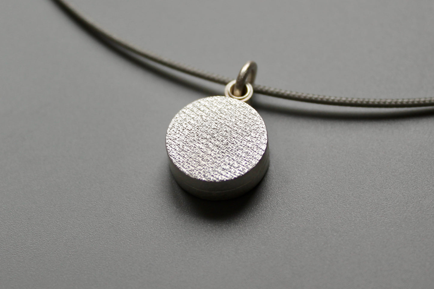 minimalist modern locket for two small photos made from textured sterling silver