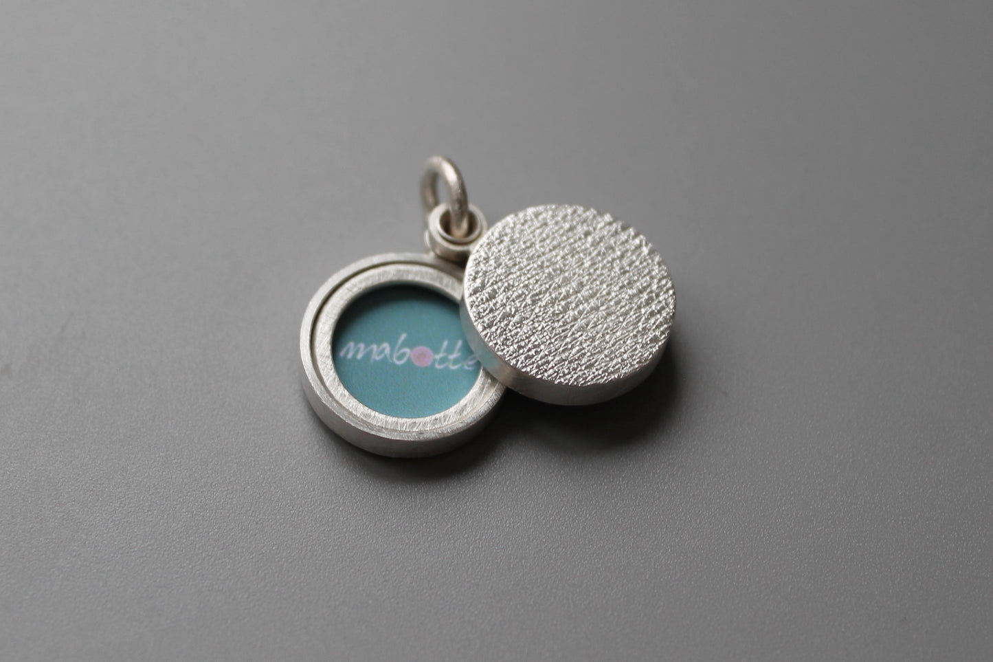 minimalist modern locket for two small photos made from textured sterling silver