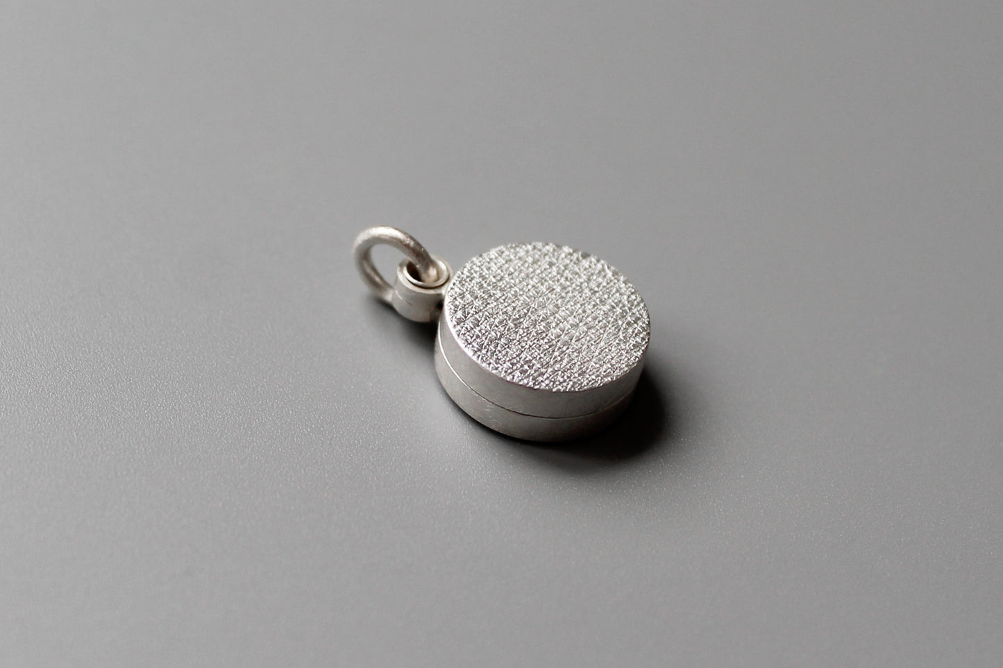 minimalist modern locket for two small photos made from textured sterling silver