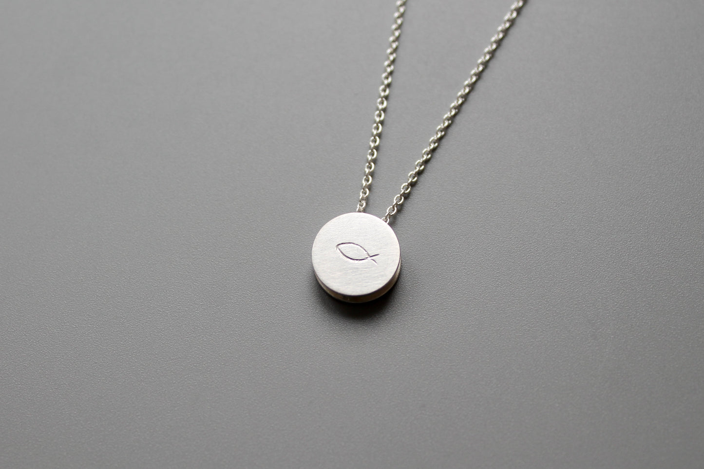 minimalist pendant necklace in sterling silver with fish symbol