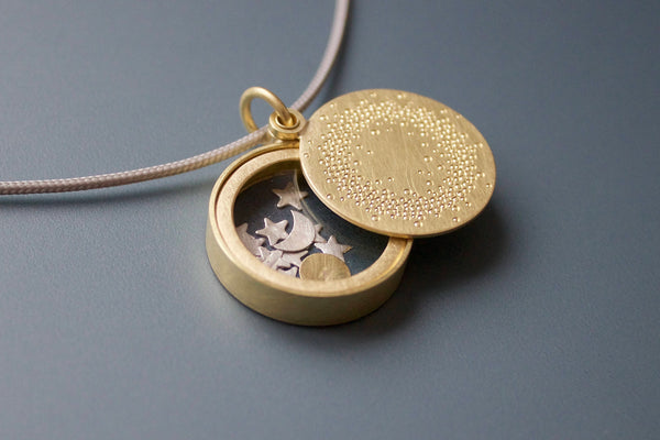 unique golden glass locket filled with sun moon and stars