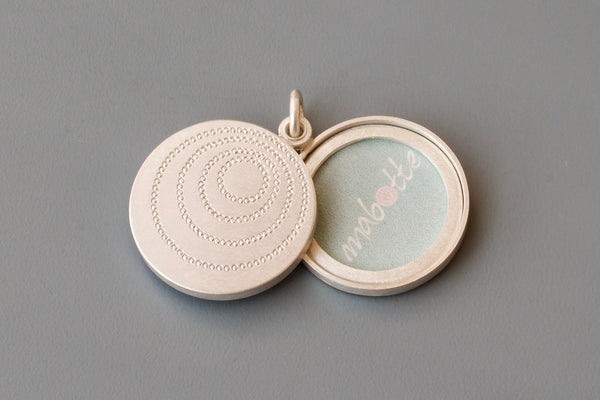 silver double sided photo locket with concentric circles