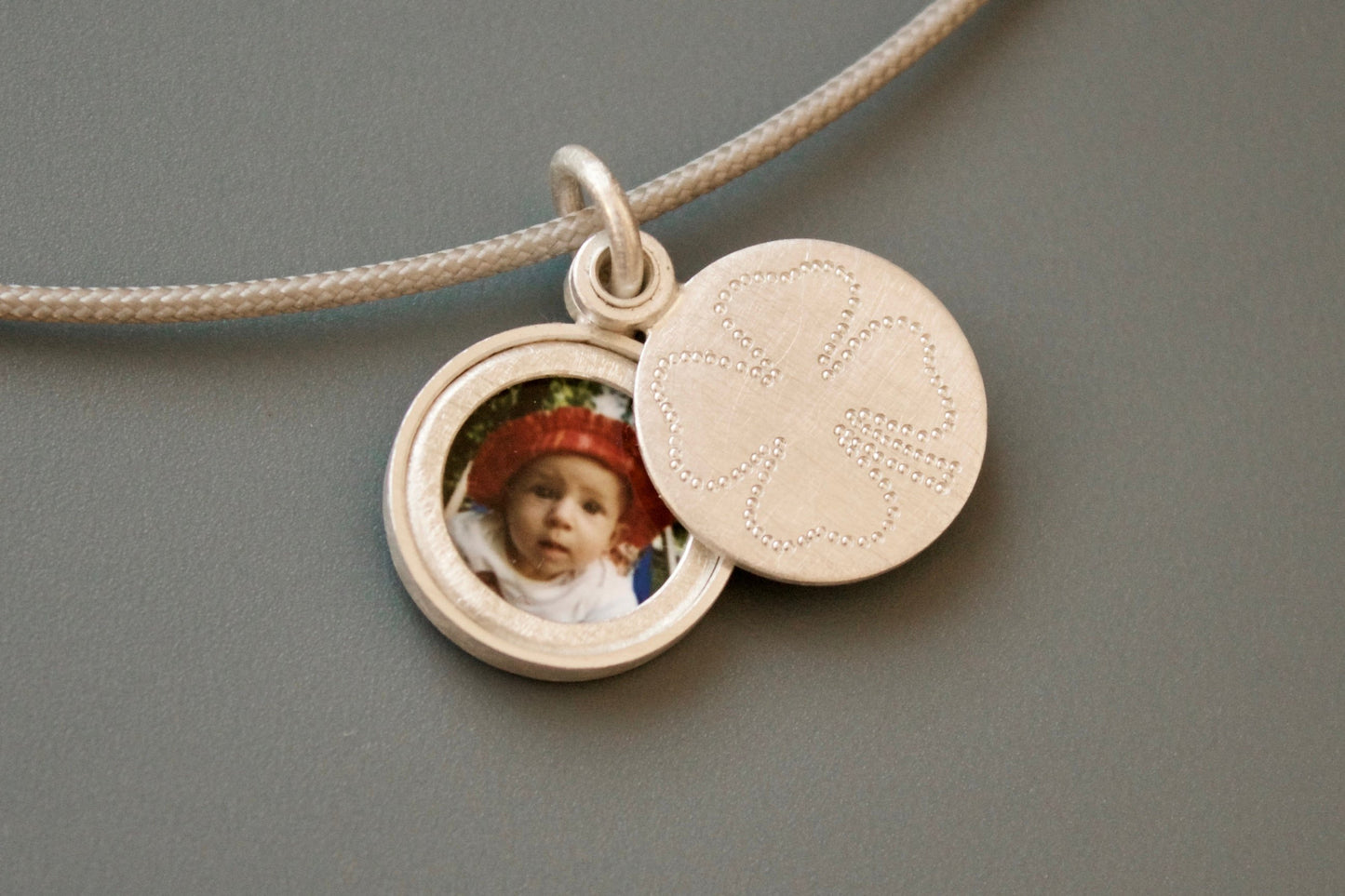 kleines silbernes Medaillon für ein Foto mit Kleeblatt als Glücksbringer 